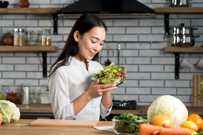 smiling-woman-holding-glass-bowl-with-salad.jpg